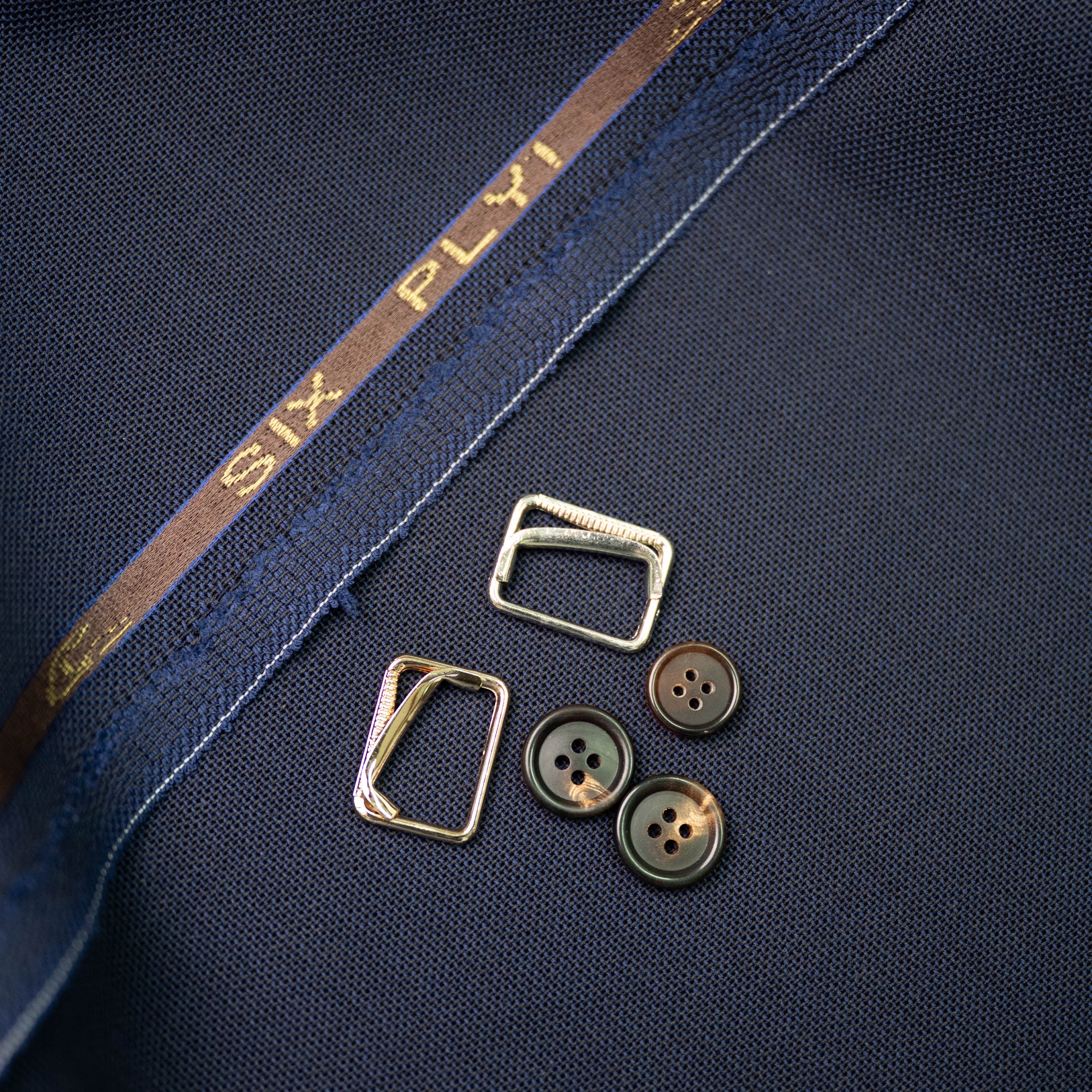 Close-up of a navy blue fabric buttons and side adjusters\