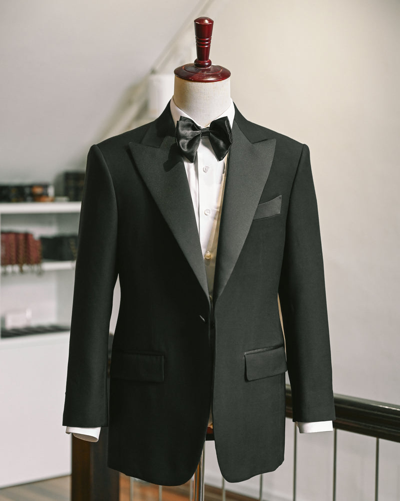 Black tuxedo jacket on a mannequin against a neutral background
