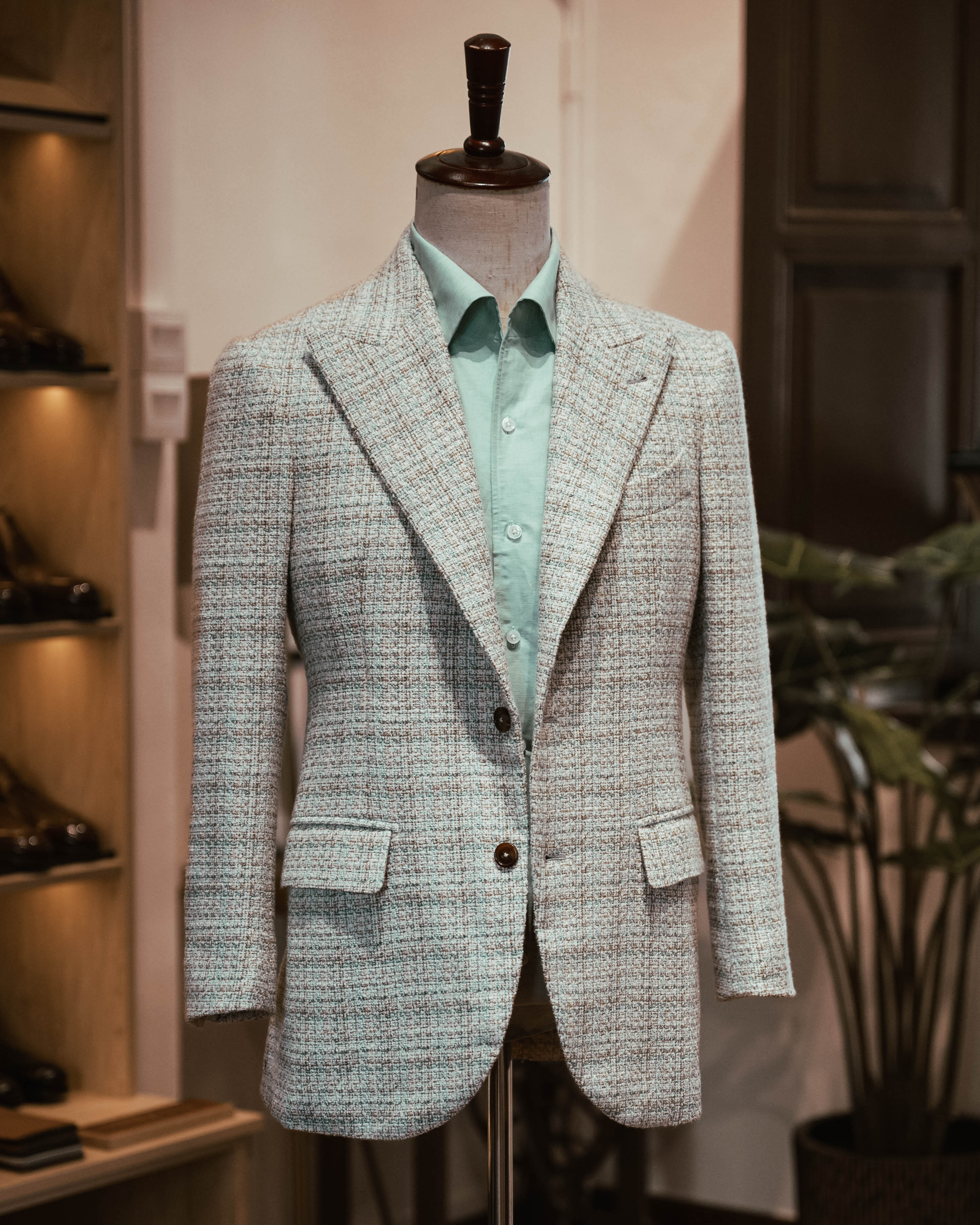 Tweed jacket on a mannequin with a light green shirt in a store setting