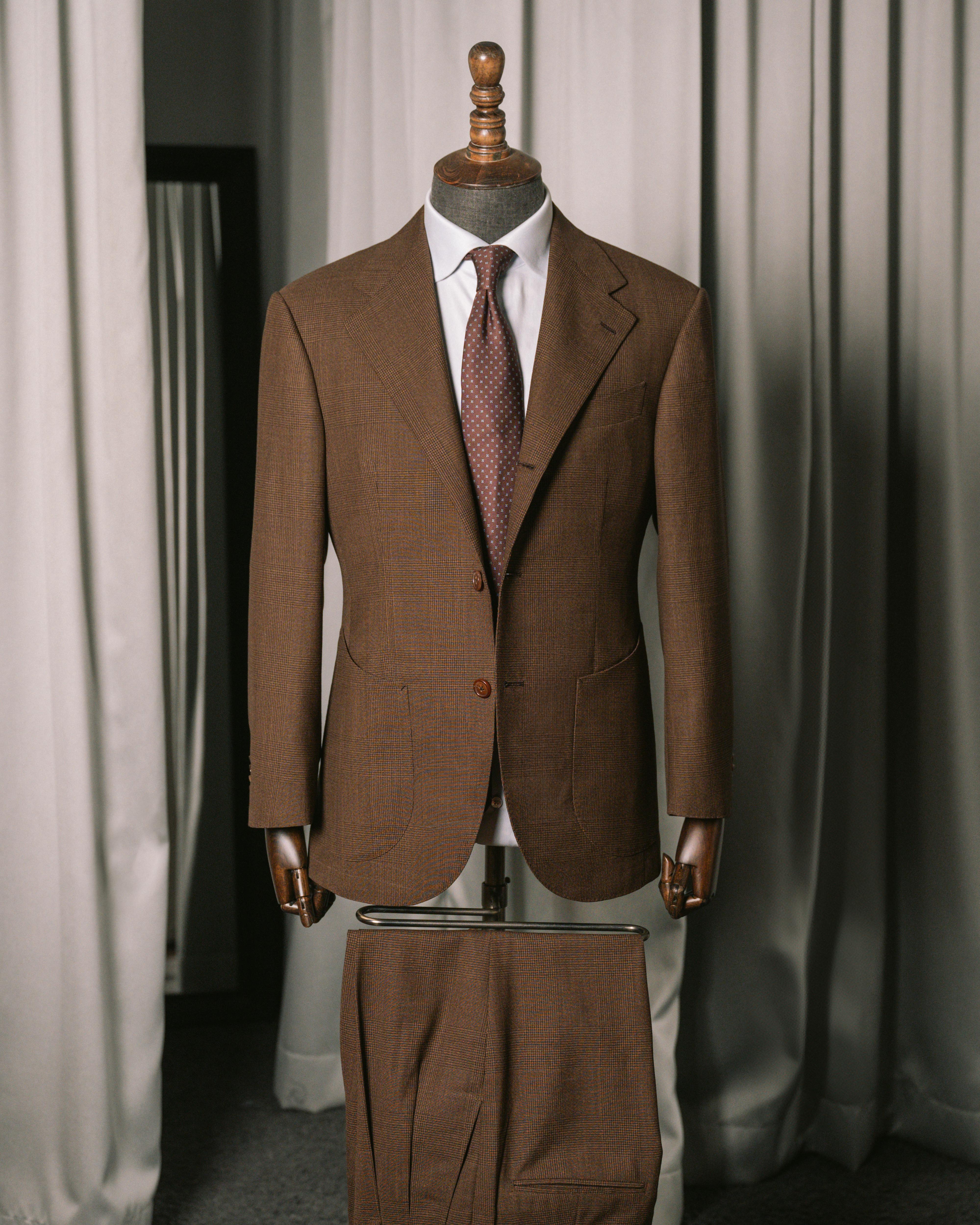 Brown suit on a mannequin against a neutral background